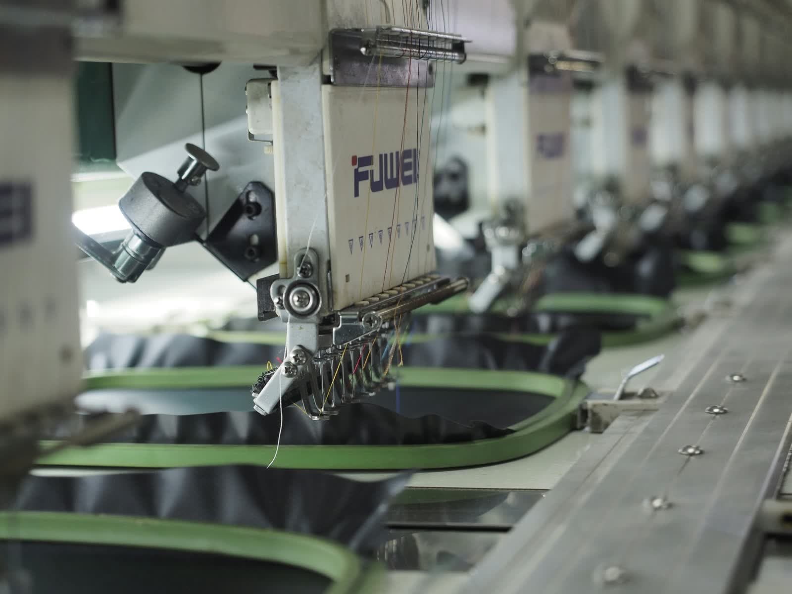 Línea de máquinas de bordado industrial trabajando en serie